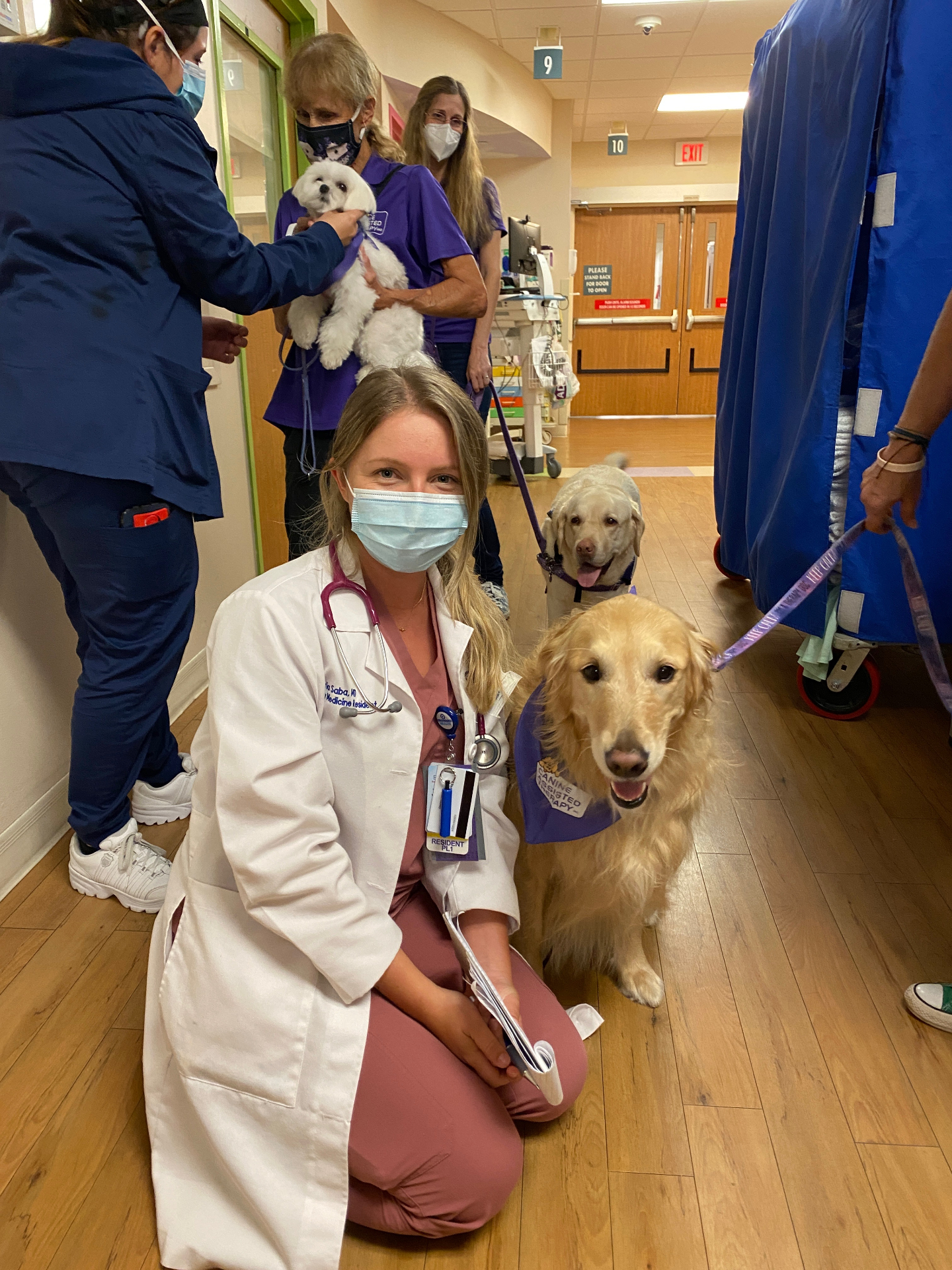 Dr. Maria Saba as an EM resident with therapy dogs in the hospital hallway