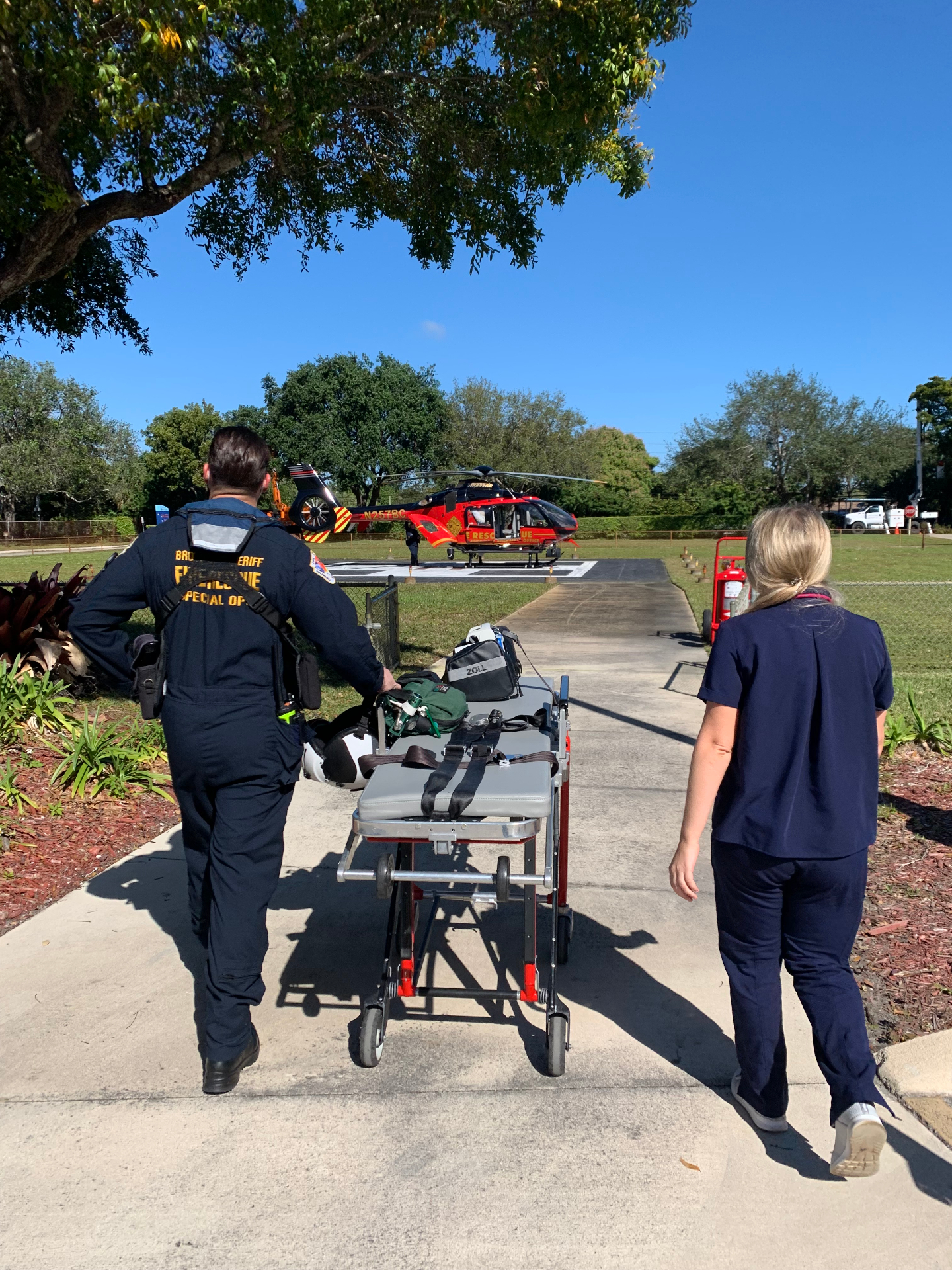 Dr. Maria Saba walking with a paramedic and stretcher toward a rescue helicopter